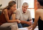 Older couple reviewing their estate planning document with an attorney. Visual concept for a blog that explains the Nevada probate process.